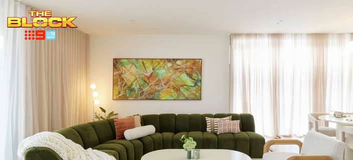 Contemporary living room featuring a curved olive-green sofa, white coffee table, neutral armchairs and colourful abstract artwork.
