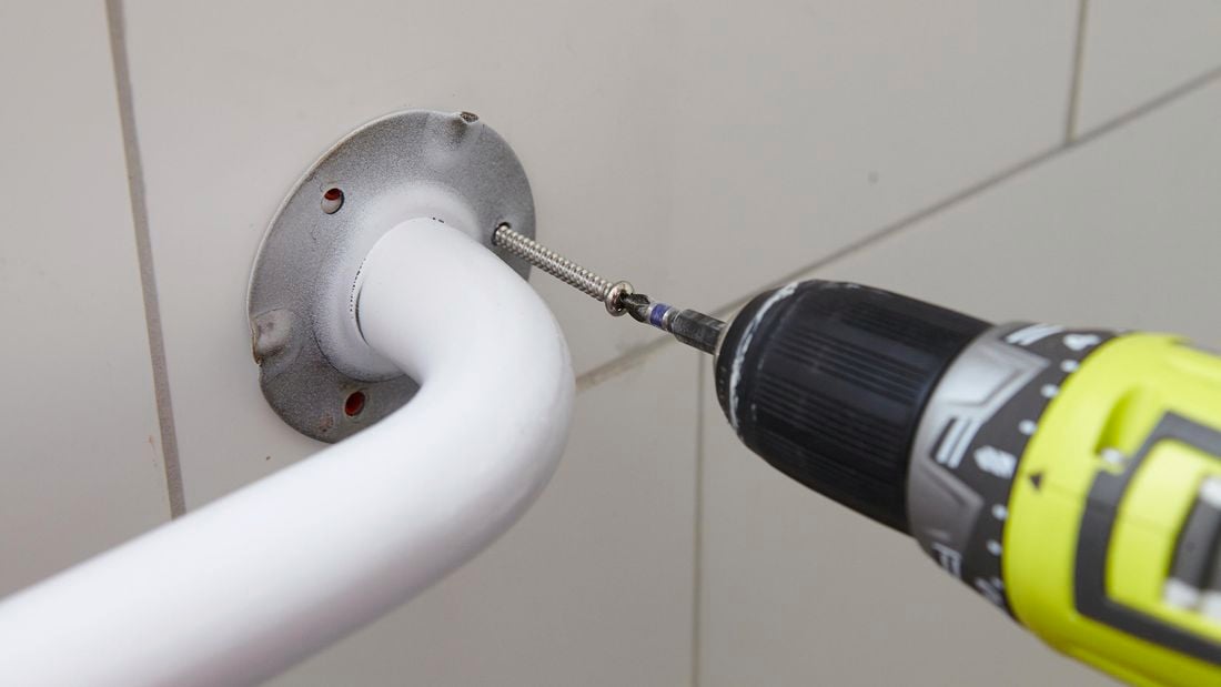 A flange being bolted into place to secure a bathroom handle