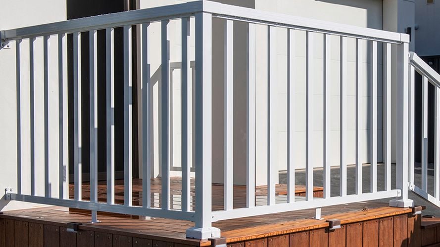 Front of house porch with wooden deck and white aluminium balustrade