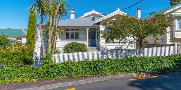 White timber house  with white picket fence