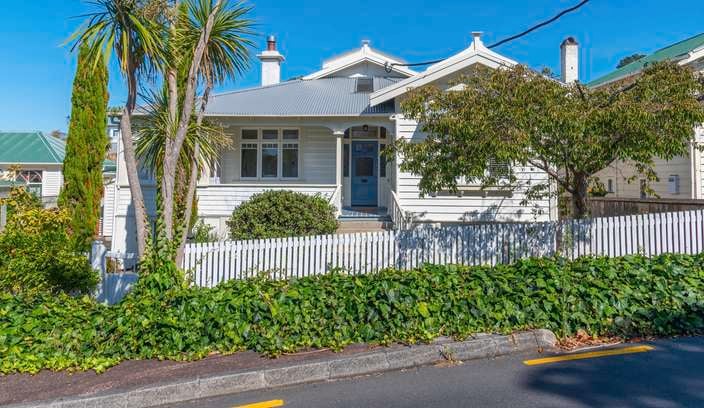 White timber house  with white picket fence
