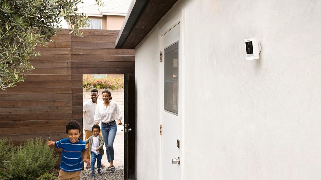 Family with children playing down the side of a house