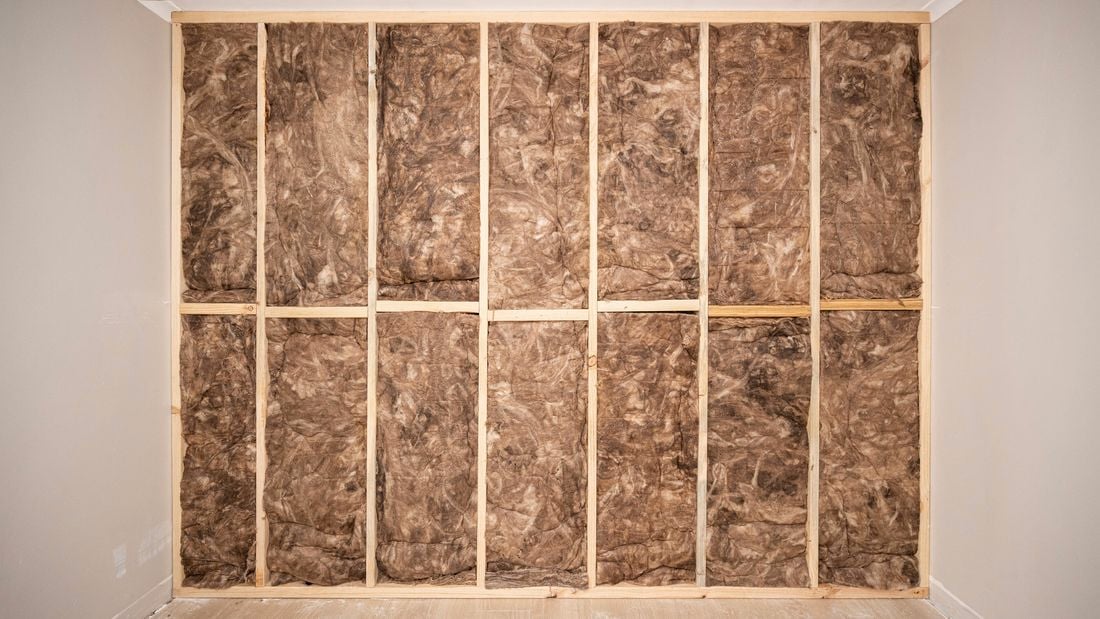 Insulation batts neatly installed between the wooden cavity