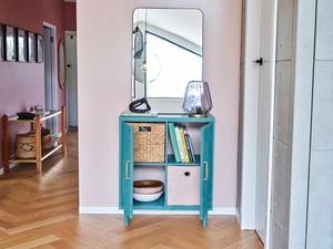 green cabinet sitting on timber floors, pink walls