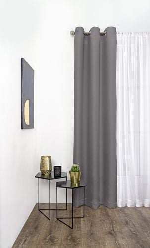 Interior of a modern living room with sheer and dark grey curtains on a metal curtain rod over the window