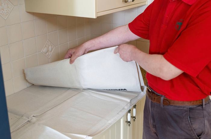 Lay drop sheet to protect surface before wall tile removal