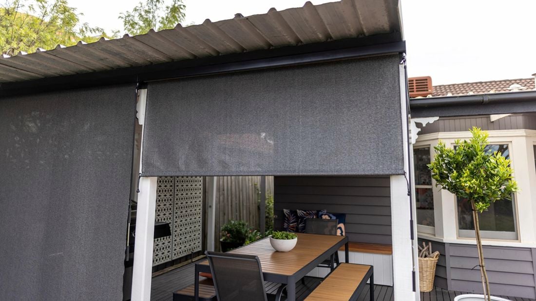 Halfway opened outdoor roller blind.