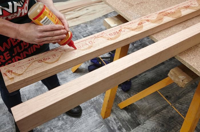 Glue being applied to the surface of a piece of wood, with the purpose of securing it to another piece of wood