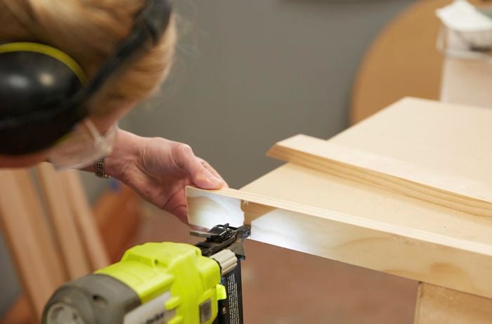 Person using nail gun to secure timber together