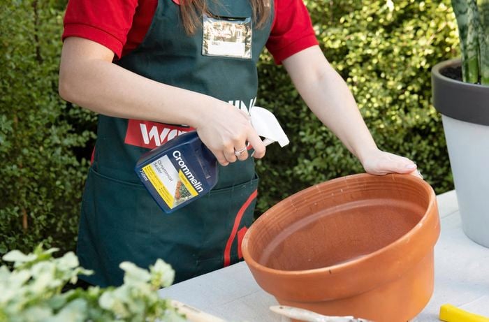 DIY - Step 2 - Team member spraying pots with primer - How to upcycle terracotta pots - Emily.jpg