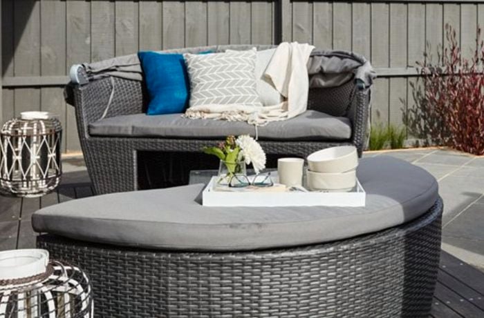 Outdoor couch with cushions and blankets.