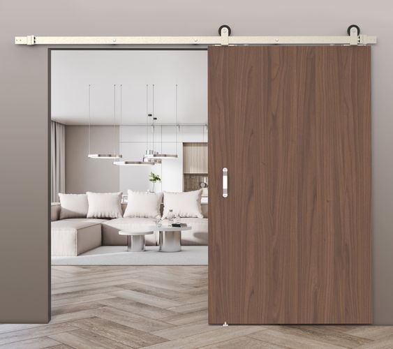 Living room interior featuring Rolltrak Satin Nickel Top Mount Barn Door Track, Stainless Steel Raised Handle, and Stainless-Steel Barn Door Guide.
