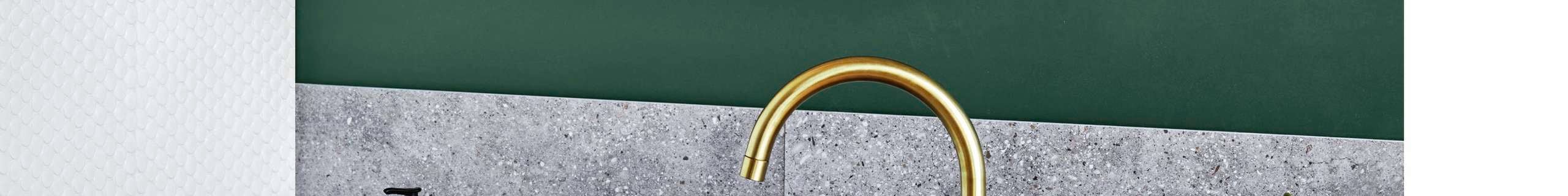 Renovated bathroom with green walls, black sink, brass tapware and cabinet.