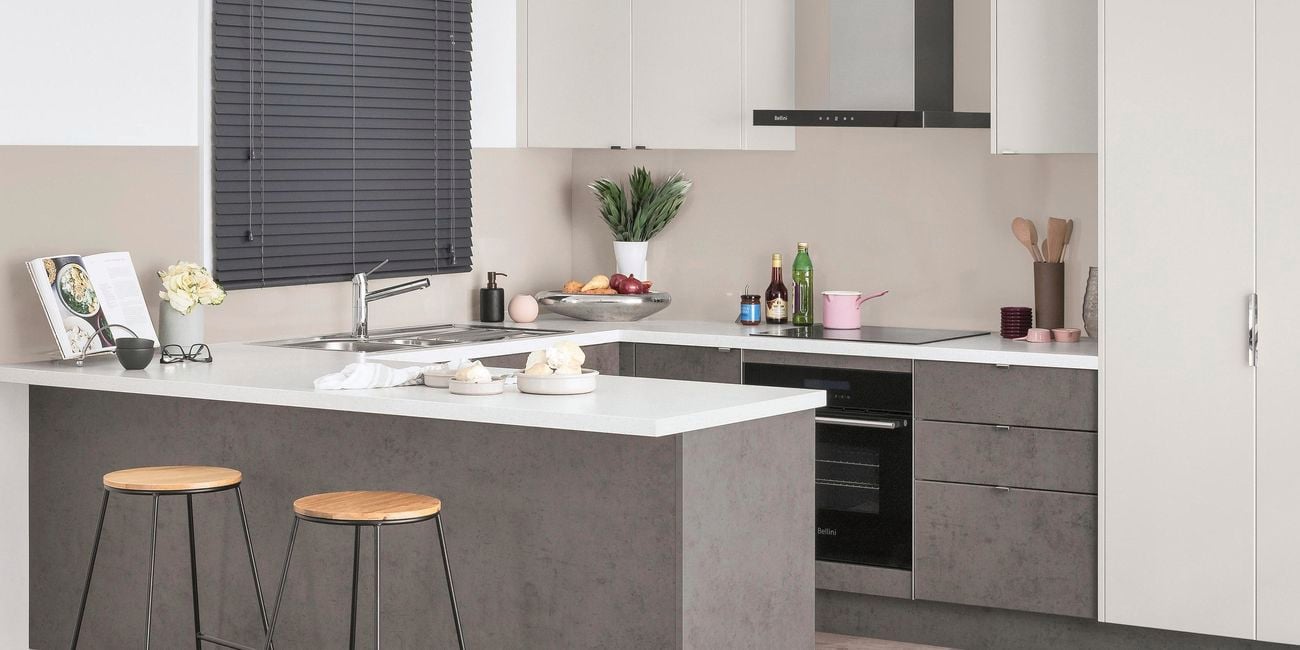 Kitchen with U-shaped kitchen benchtops, stainless steel sink and two stools