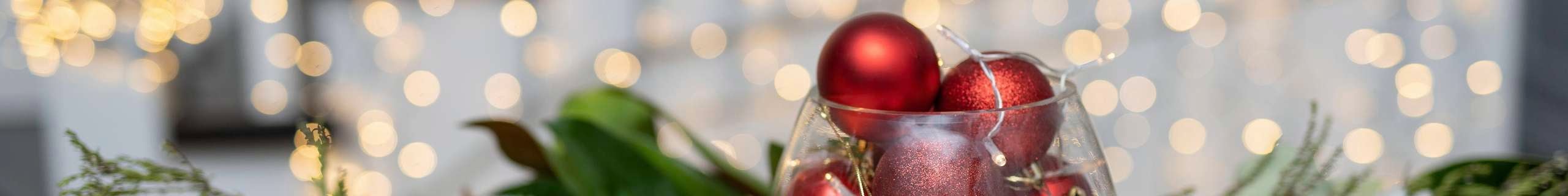 A Christmas bauble hanging from a pine tree