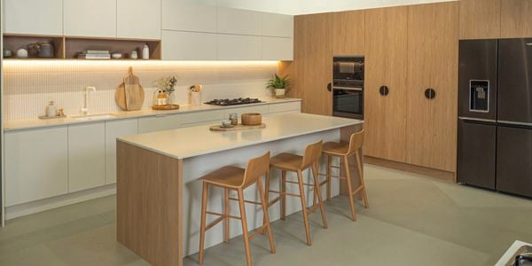 Kitchen - with cream beach top, light timber cupboards and 3 timber stools