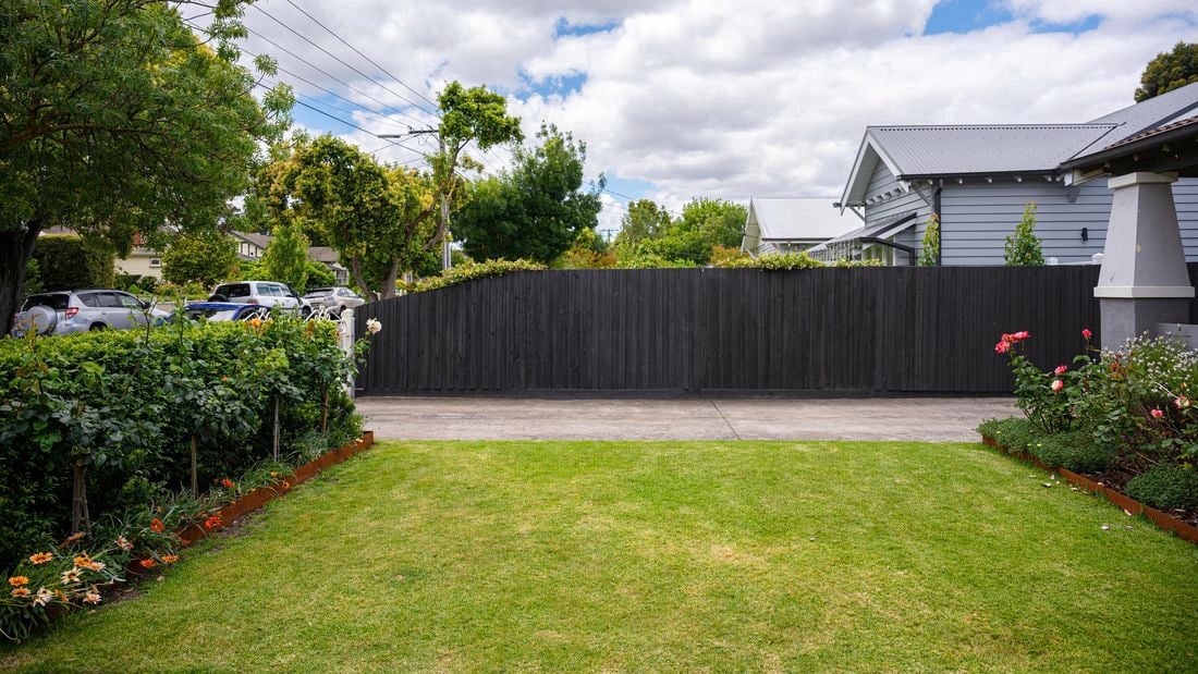 A beautiful garden with a freshly painted fence.