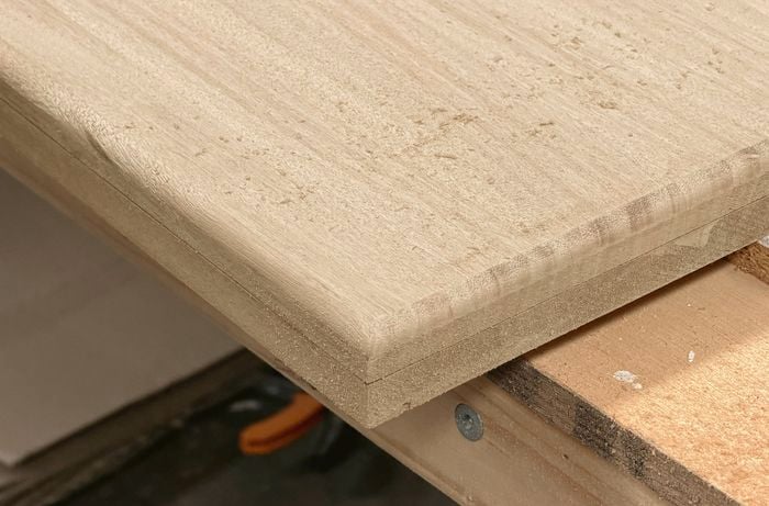 Close-up of a sanded timber panel edge showing a smooth, rounded finish.