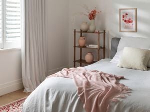 A cosy bedroom in a warm healthy home with a throw and rug