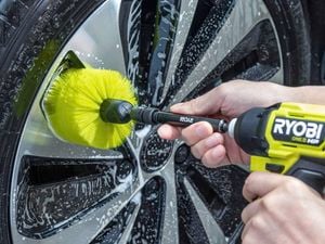 Drill brush attachment cleaning a car wheel