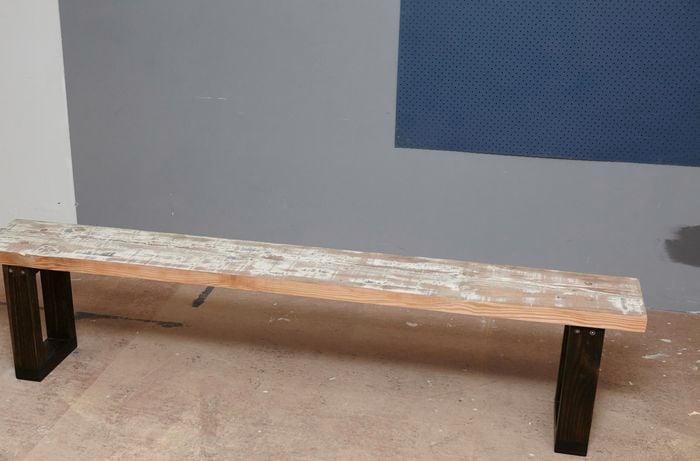 A bench seat with recycled timber top and black legs