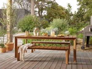 Outdoor table & bench with a pizza oven in a backyard