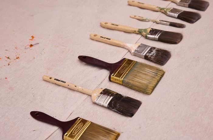 Paint brushes are neatly laid out to dry before being stored in a cool, dry place