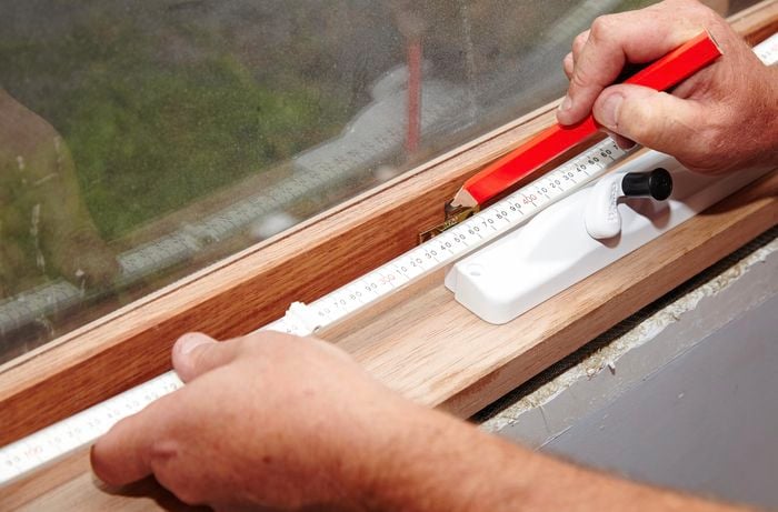 A window being marked for the installation of a winder