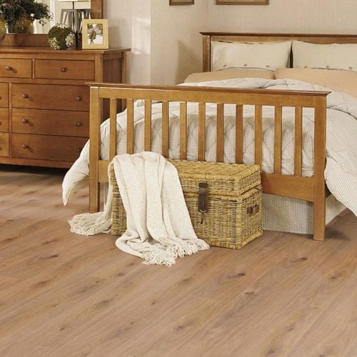 Bedroom with floorboards, timber bed frame, timber cabinet and rattan chests.