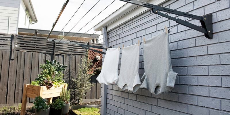 T-shirts hanging from a wall-mounted clothesline.
