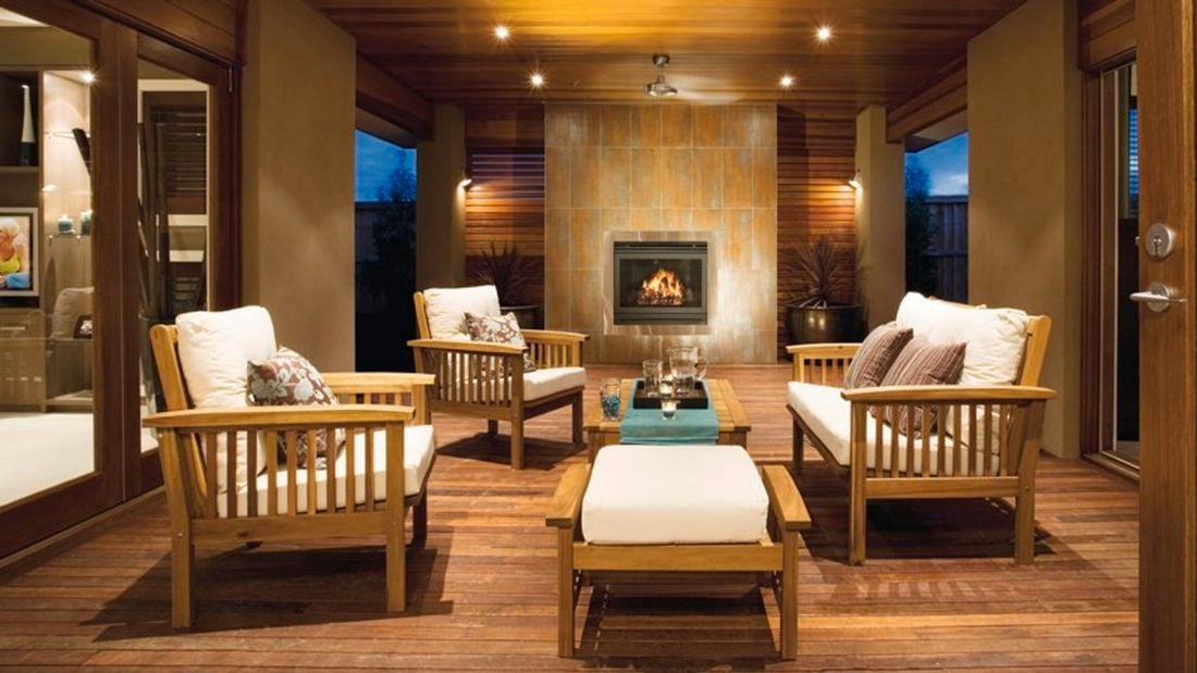 A spacious interior setting with mood lighting, fireplace, couches and timber floors.