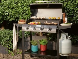Jumbuck bbq with food cooking in front of green hedges