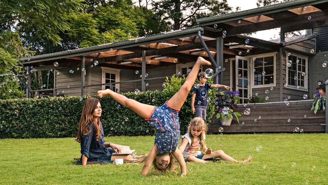 Kids playing on lawn, blowing bubbles, doing cartwheels