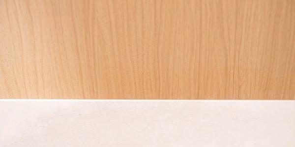 Smooth finished silicone sealant applied along the gap between timber and benchtop.
