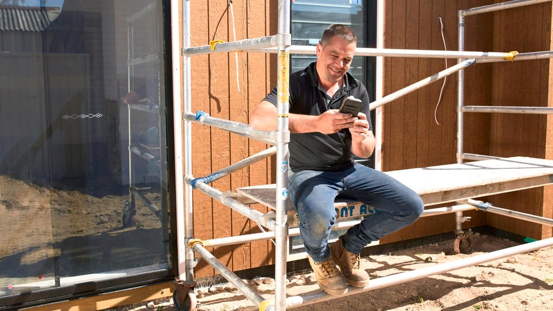 A person sitting on scaffolding outside.