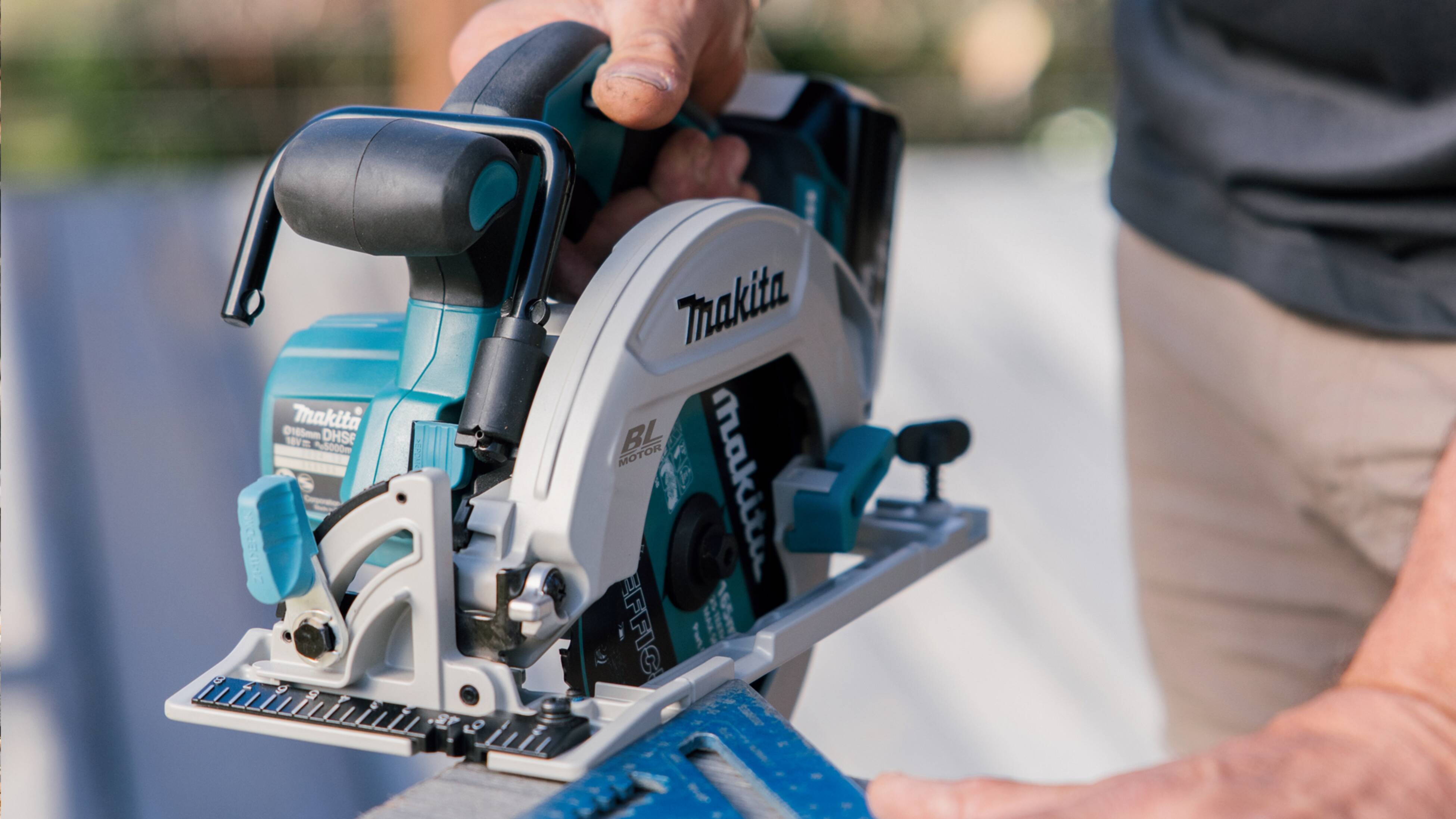 A close up of a Makita circular saw being used outside.