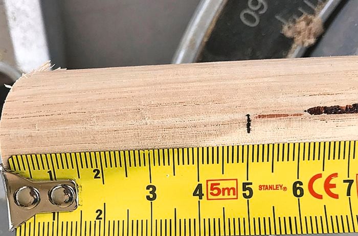 A ruler and pen being used to mark pieces of dowel to become coat pegs