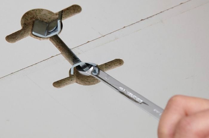 Person tightening cabinet joiners with small spanner