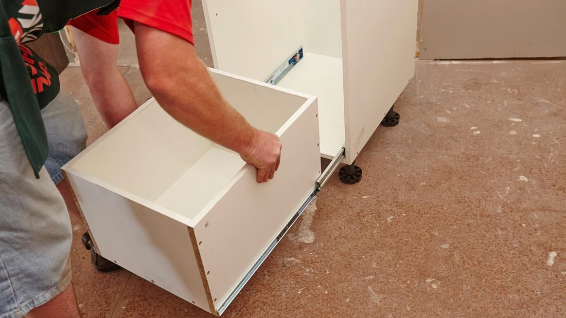 Person sliding drawer into shelving unit.