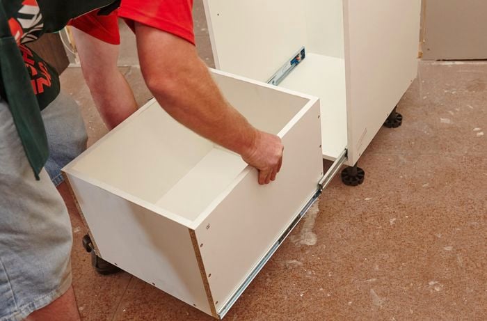 Person sliding drawer into shelving unit.