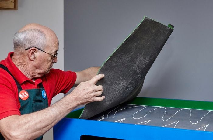 Person gluing felt to table top