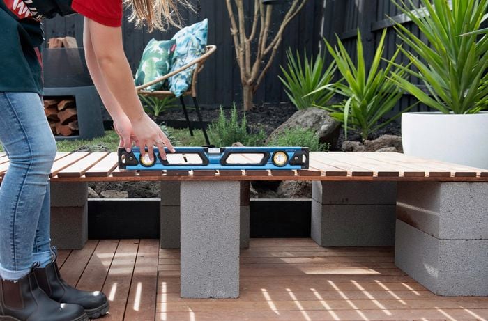Person using spirit level on timber.