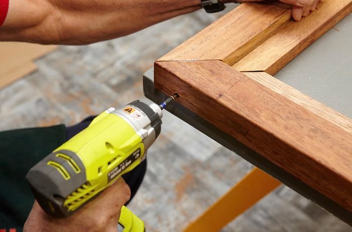 Person drilling two bits of timber frame together.