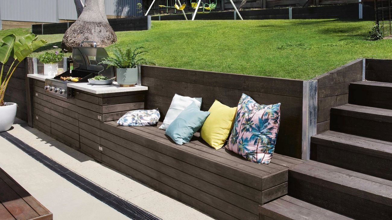 Seating in an outdoor setting cut out of lawn slope with throw cushions