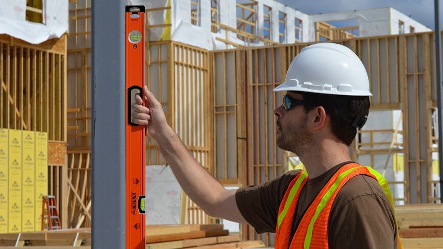Person using box level to measure level of pillar
