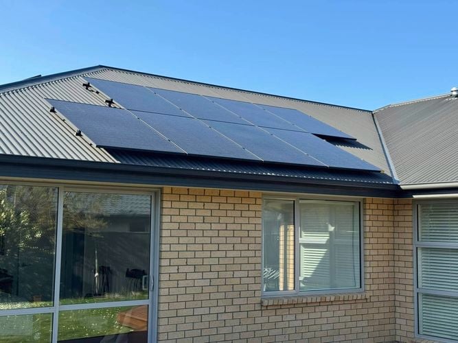 Solar Panels on the roof of a brick house.