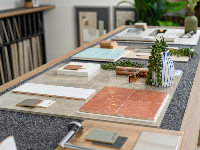 Different styles and colours of tiles on display on a wooden table.