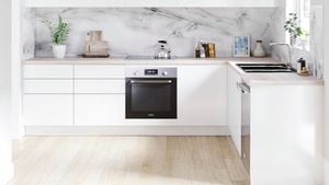 Kitchen with white and timber cabinets, timber benchtop and marble splashback.