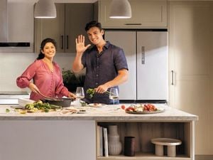 Man and woman standing in a kitchen facing at camera.