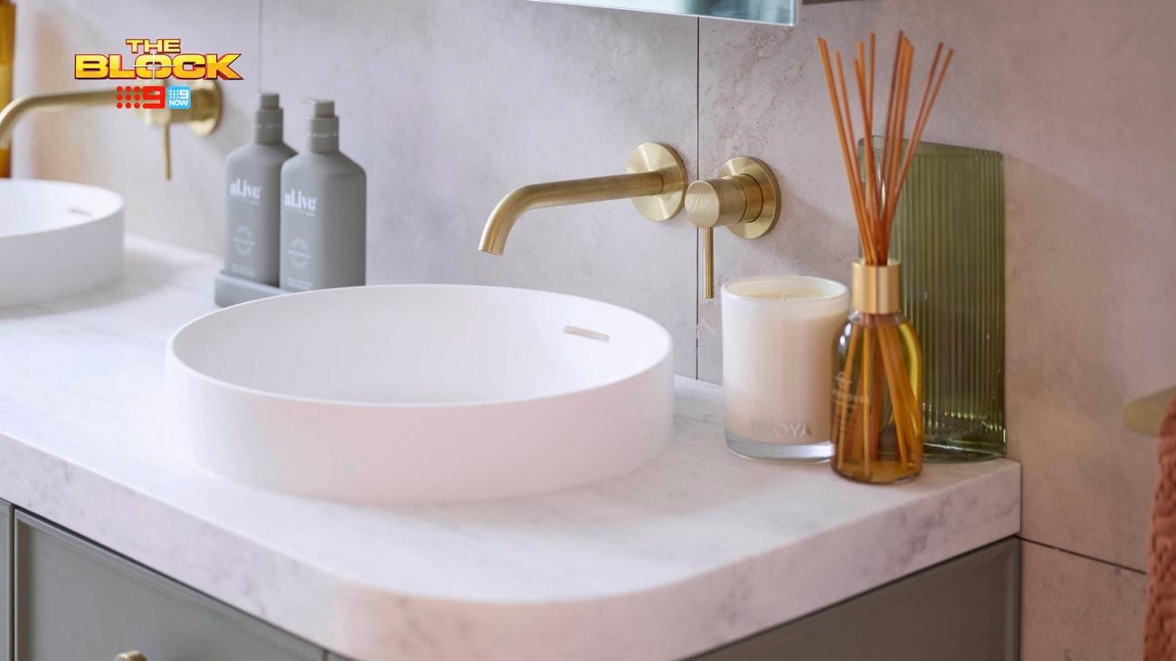 Round basin with gold tapware on a blue vanity